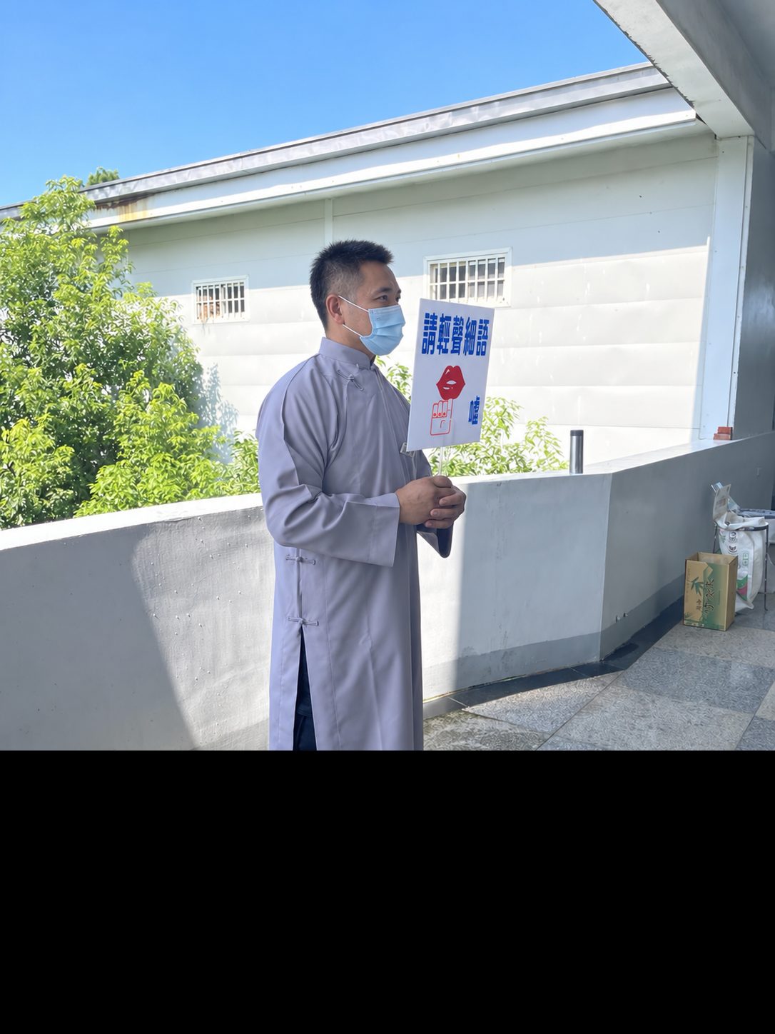 禮規組值勤人員手持請輕聲細語告示牌，守護道場寧靜